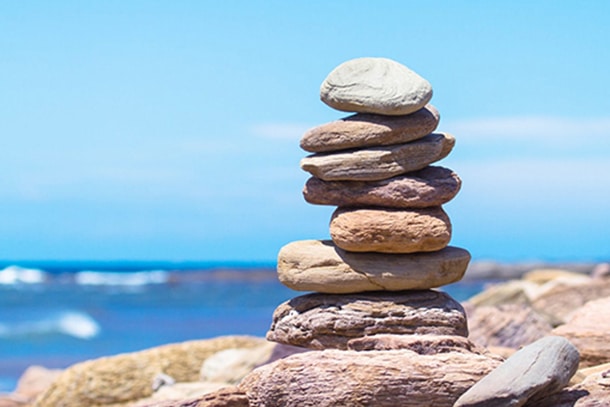 stacked balancing rocks practicing patience and serenity for mental health improvement