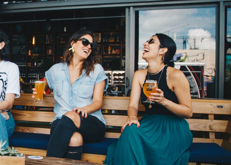 two women drinking beer not paying attention to the effects of alcohol and covid19