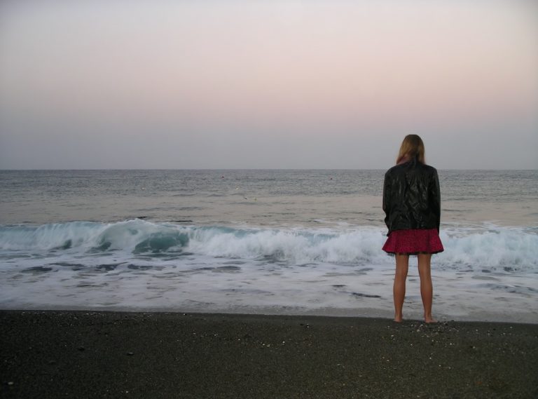 woman standing with her back to the camera looking at the ocean to symbolize antidepressant abuse and addiction