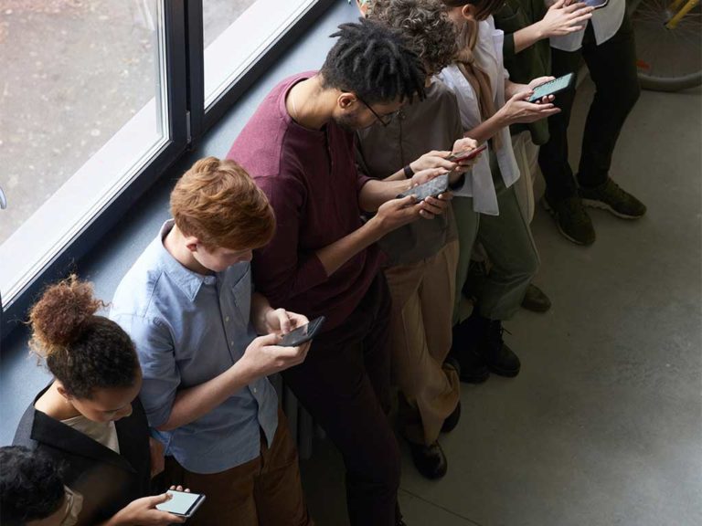 people standing inside on their cellphones to symbolize cyberbullying and substance abuse