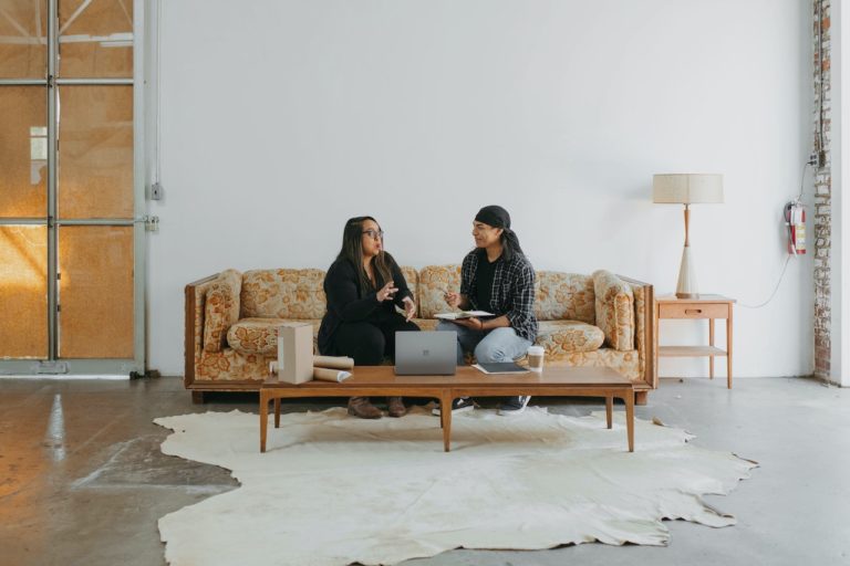 two people sitting on a couch at a rehab center discussing tips for healthy habits and self-care in recovery
